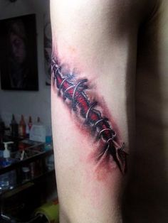 a tattoo on the arm of a man with red and black ink in an abstract style