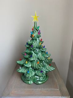 a green ceramic christmas tree sitting on top of a wooden table