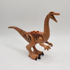 a toy dinosaur with its mouth open on a white background