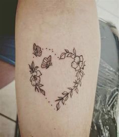 a heart shaped tattoo with flowers and butterflies