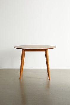 a wooden table sitting on top of a cement floor