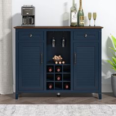 a blue cabinet with wine bottles and glasses on it next to a potted plant