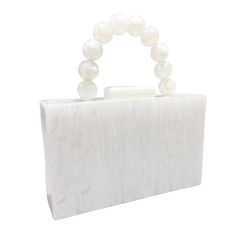 Our Cecelia clutch is an exquisite fashion statement. Hand crafted and beautifully made, truly a work of art! This clutch comes with a 4 inch beaded handle and a gold crossbody strap. Engraved with the LINNY CO brand on reverse side of the purse. Details and materials are outlined below. Material: Acrylic Color: Pearl White Fabric Lined Fits an iPhone 14, card case, lipstick and single key Magnetic Closure Size of actual bag exclusive of the handle: 18x11x4.5mm Handle with care, could break if d Trendy Top Handle Clutch As Gift, Elegant White Bag With Round Handle, Chic Beaded Evening Bag With Top Handle, Chic Beaded Top Handle Evening Bag, Elegant Pearl Handle Crossbody Evening Bag, Chic White Handheld Clutch, Elegant Crossbody Evening Bag With Pearl Handle, Crossbody Evening Bag With Pearl Handle, Trendy Evening Bag With Pearl Handle For Gift