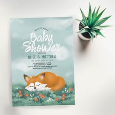 a baby shower with a sleeping fox on it's back next to a potted plant