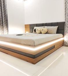 a large bed sitting in the middle of a room next to two lamps on either side of it