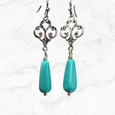 Silver filigree dangle earrings featuring turquoise Czech glass teardrop beads. Turquoise and silver earrings are a timeless choice that will never go out of style. Hypoallergenic ear wires (nickel and lead free). Select ear wire style at checkout. Artisan glass beads produced in small quantities in the Czech Republic A gift for you or someone special, earrings are carded and in an organza bag. More of my silver earrings: https://www.etsy.com/shop/JezaJewelry?ref=simple-shop-header-name&listing_ Elegant Turquoise Beaded Earrings For Gift, Handmade Turquoise Chandelier Earrings, Nickel-free Sterling Silver Turquoise Chandelier Earrings, Elegant Turquoise Beaded Earrings Nickel-free, Elegant Handmade Turquoise Teardrop Earrings, Elegant Turquoise Beaded Earrings Nickel Free, Elegant Handmade Turquoise Chandelier Earrings, Turquoise Teardrop Chandelier Earrings In Sterling Silver, Blue Filigree Dangle Jewelry