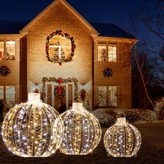 three lighted pumpkins in front of a house