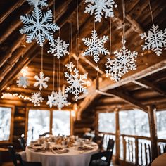 snowflakes hanging from the ceiling in a rustic cabin dining table set for two