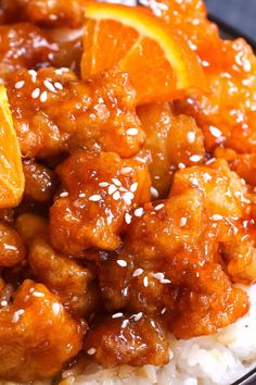 orange chicken with rice and sesame seeds on a plate