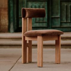 a wooden chair sitting on top of a sidewalk