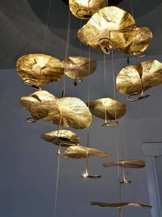 a chandelier made out of brass leaves hanging from the ceiling