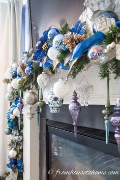 blue and white ornaments are hanging on the mantle