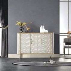 a white and gold sideboard in a room with black curtains on the windowsill