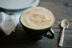 there is a cup with some sugar on it and a spoon next to it in the foreground