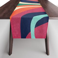 a colorful table runner on top of a wooden table