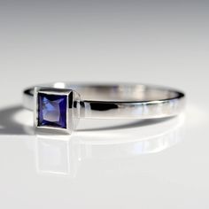 A square/princess cut is set in a tapered bezel. Petite and low profile. Band is approximately 2x1mm 4mm princess/square cut dark blue Chatham sapphire center stone Made in platinum Ring Size 7 Shiny finish Contact us if you are interested in having this ring resized before shipping. Rectangular Lab-created Sapphire Ring For Anniversary, Anniversary Rectangular Lab-created Sapphire Ring, Classic Rectangular Lab-created Sapphire Ring, Formal Square Cut Sapphire Ring, Classic Sapphire Ring With Rectangular Stone, Rectangular Sapphire Ring In White Gold, Rectangular Sapphire Anniversary Ring, Modern Radiant Cut Sapphire Ring For Formal Occasions, Modern Asscher Cut Sapphire Jewelry