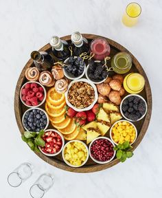 a wooden platter filled with fruit and drinks