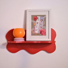 a shelf with an orange ball and some pictures on it