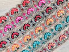 multicolored flowers are displayed on the edge of a piece of cloth, which has been sewn together