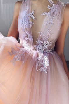 a woman wearing a pink dress with white flowers on it