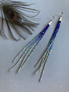 "Wind Crest" A playful harmony of cool navy blue and silver seed beads rest against threads of bright blue and sky blue. These long earrings feature a splash of mixed color accents. A pop of electric tribal colors make these earrings a true statement to wear. 925 silver earwires finish the look. The last photo shows a similar pair of 9 inch earrings worn for scale. Please choose your length at check out: 4 inches 6 inches 9 inches Photos show our long pair of earrings measuring 6 inches from top of earwire to bottom. Your jewelry will come beautifully packaged and ready to give as a gift. Each piece comes in a hand decorated brown paper gift box.  For multiple purchase orders - Please let me know in the "notes to seller" upon checkout if you need your order packed in separate gift bags or Cheap Elegant Blue Beaded Earrings, Bohemian Blue Beaded Earrings With Silver Beads, Adjustable Blue Beaded Earrings With Silver Beads, Adjustable Blue Earrings With Silver Beads, Long Beaded Earrings, Color Accents, Paper Gift Box, Handmade Jewelry Diy, Beaded Dangle Earrings