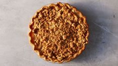 a pie sitting on top of a table covered in caramel sauce and crumbs