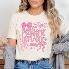 a woman wearing a t - shirt that says pediatric hemone with pink bows on it