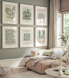 a living room with green walls and pictures on the wall above the couch, along with vases filled with flowers