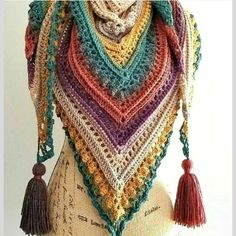 a crocheted shawl with tassels on it