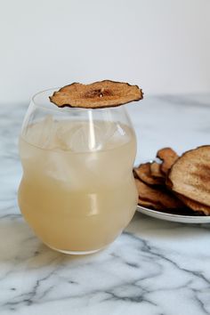 a glass filled with liquid next to some crackers