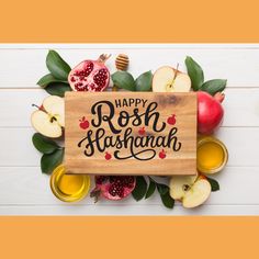 a wooden sign that says happy rosh hash hashanah surrounded by apples, honey and pomegranates