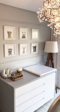 a white dresser with pictures on the wall