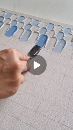 a person is using a knife to cut out the pattern on a piece of fabric