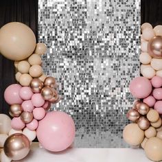 balloons and streamers are arranged in front of a silver sequin backdrop for a party