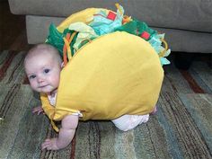 a man with white hair and sunglasses is wearing a taco costume while sitting on the floor