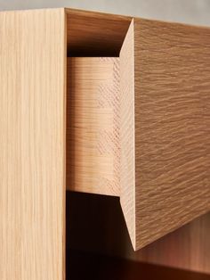 a close up view of the corner of a wooden cabinet with wood grains on it