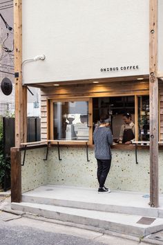 a man standing at a counter in front of a coffee shop