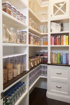 an organized pantry with lots of books, cereals and other items on shelves in the corner