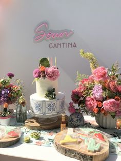 a table topped with lots of cakes and flowers