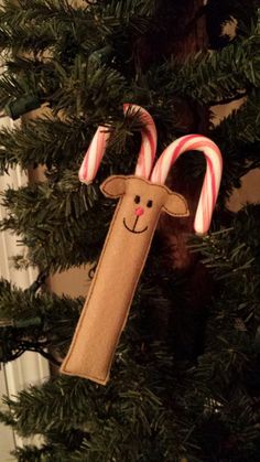 a christmas ornament hanging from the top of a tree with candy canes