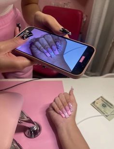 a woman is using her cell phone to take a picture with the fingernails