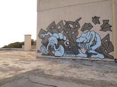 graffiti painted on the side of a building in an empty lot with no people around