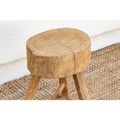 a wooden stool sitting on top of a carpeted floor next to a white wall