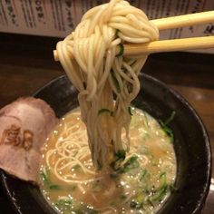 chopsticks sticking out of a bowl of noodles