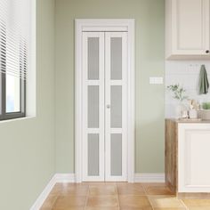 an empty kitchen with green walls and white cupboards on the wall, along with tile flooring