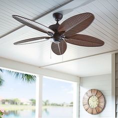 a ceiling fan is hanging from the ceiling in front of a large window with shutters