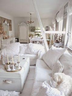 a living room filled with lots of white furniture