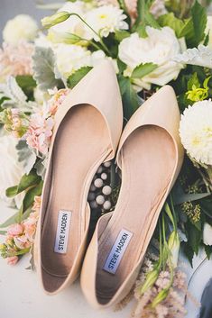 two pairs of shoes sitting on top of flowers