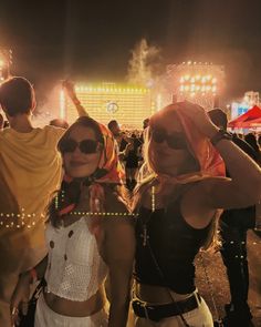 two women standing next to each other at a music festival