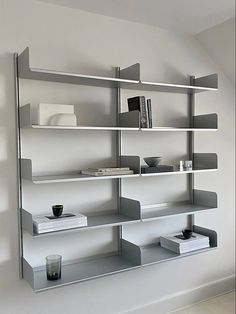 a book shelf with books and cups on it